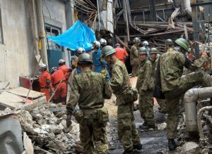 Japanese military search and rescue teams at collapsed Daio Paper factory in Yatsushiro, Kumamoto, after 2026 earthquake
