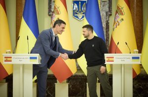 Pedro Sánchez shaking hands with Volodymyr Zelenskyy in Kyiv, Spanish and Ukrainian flags in background