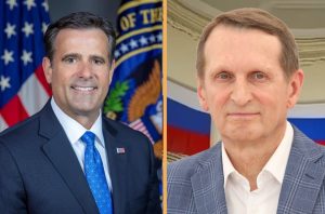 A side-by-side composite photo showing CIA Director John Ratcliffe on the left in front of an American flag and CIA seal, and Russian Foreign Intelligence Chief Sergey Naryshkin on the right in front of a Russian flag backdrop, separated by a thin gold line.